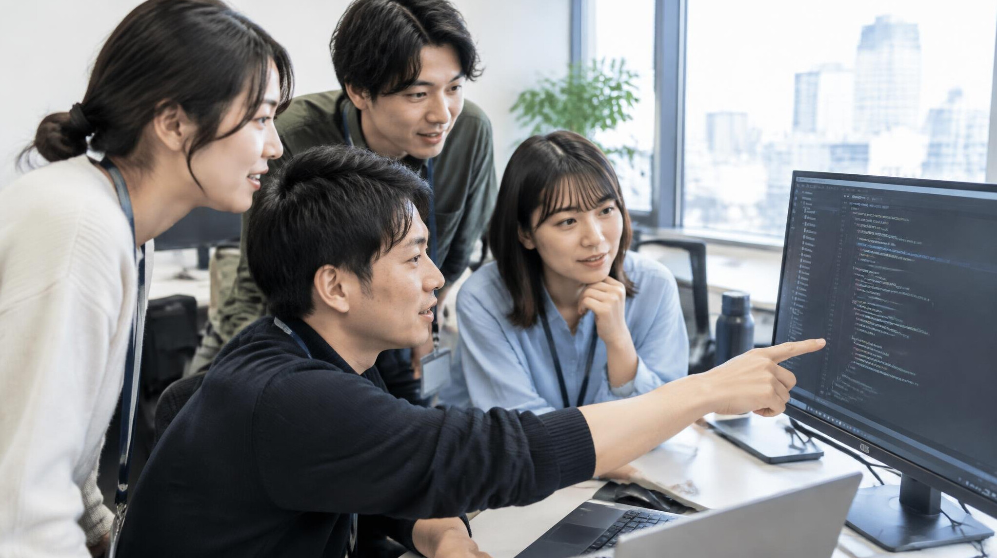 Group of people discussing in front of a computer screen